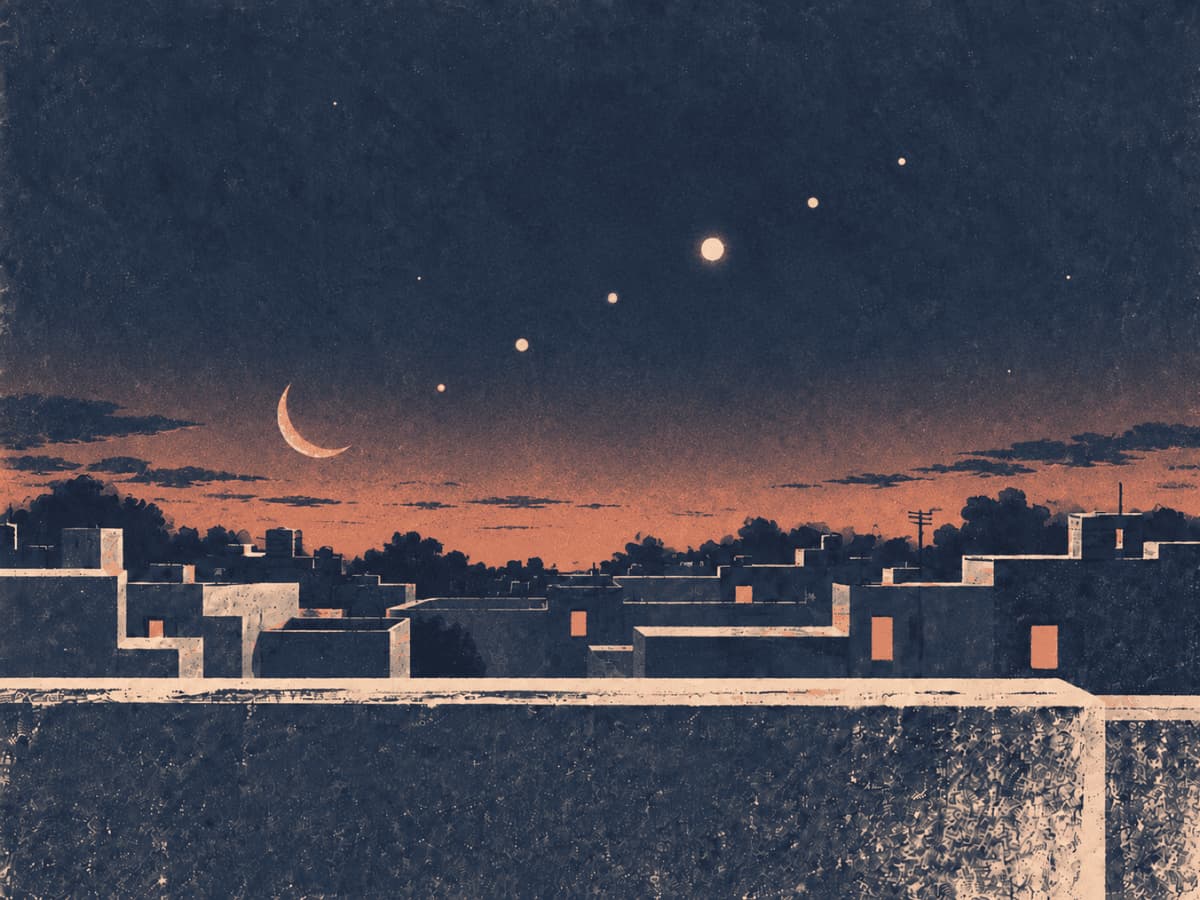 A crescent Moon and bright planets strung in a line above city rooftops at dusk
